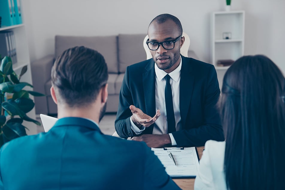 Male tax relief specialist in a suit and tie meeting with two clients